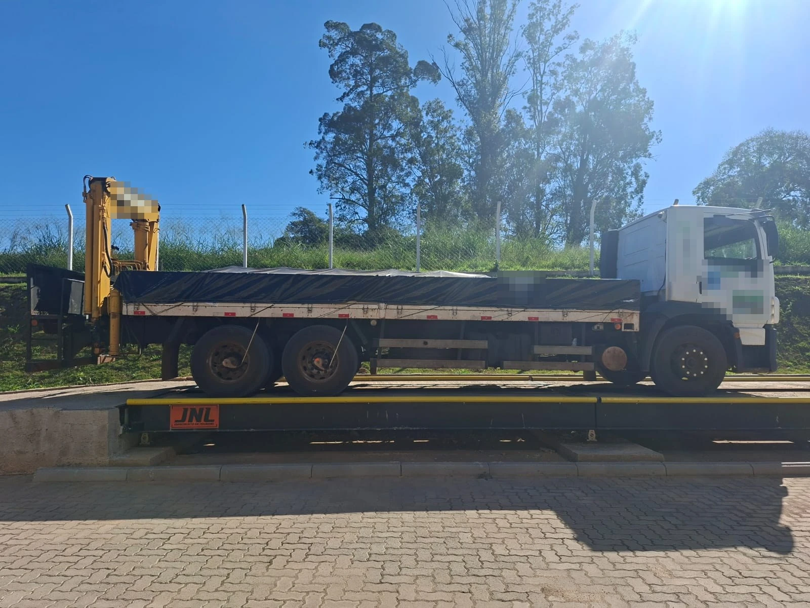Camión sobre una báscula camionera BRMC instalada, con la marca JNL en el lateral de la báscula