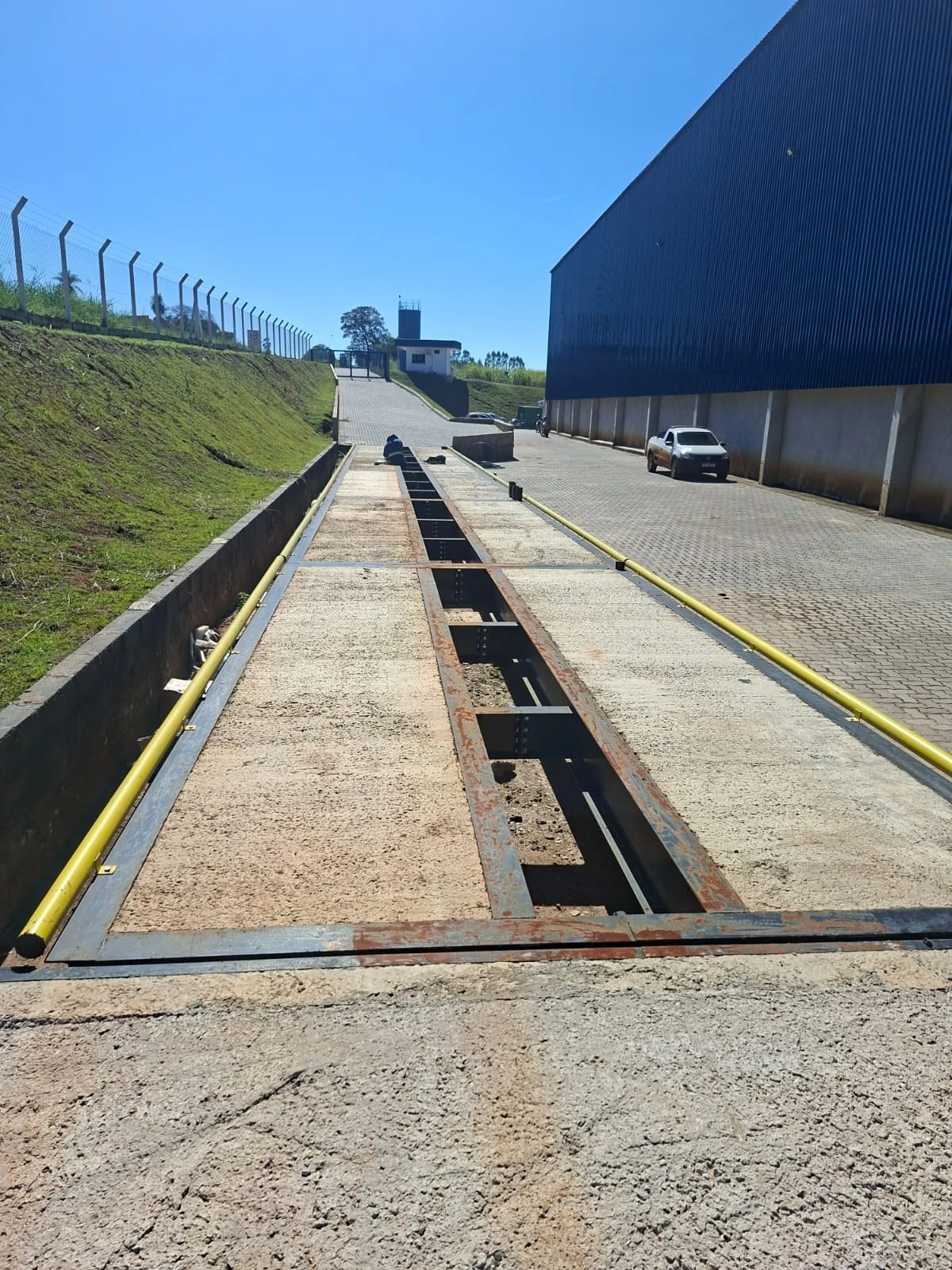 Pista de báscula camionera JNL junto a un galpón