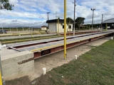 Báscula de plataforma metálica instalada, con barra amarilla lateral