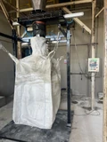 Ensacadora de big bag JNL instalada, con el bag sujeto al traba-bolsa y el panel JNL en la pared
